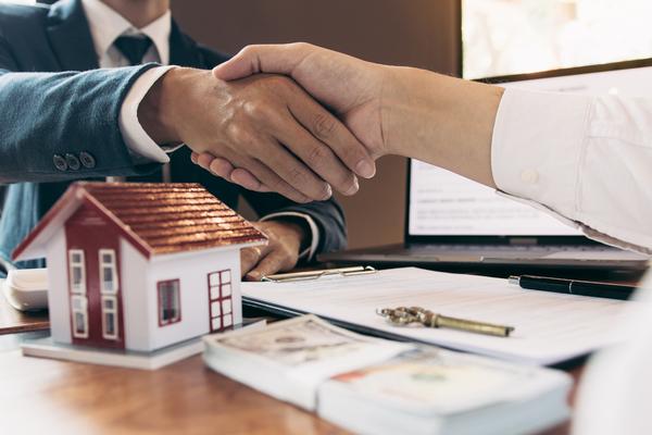 Professionals shaking hands over rental property agreement